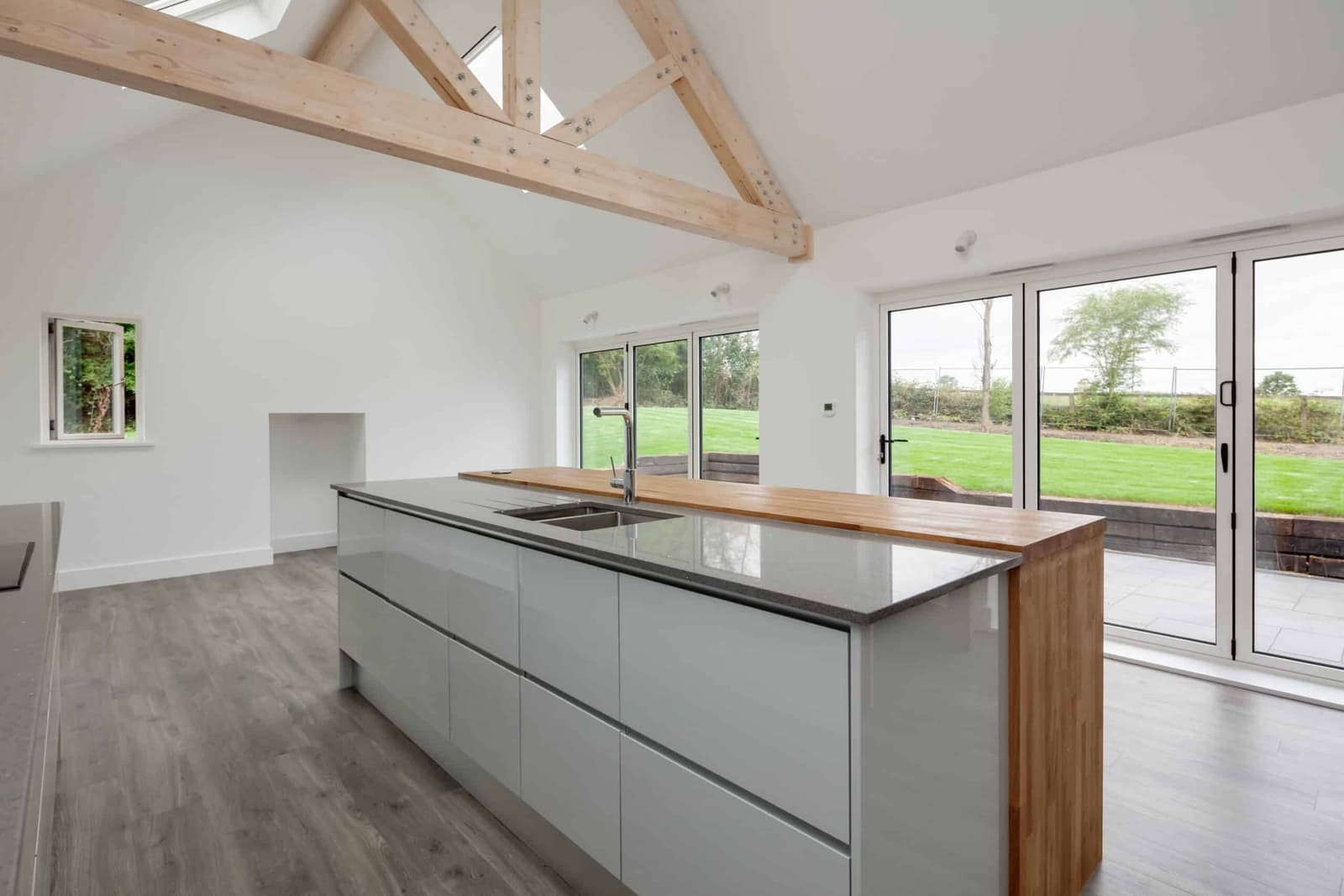 Modern open plan kitchen with a vaulted ceiling and garden view