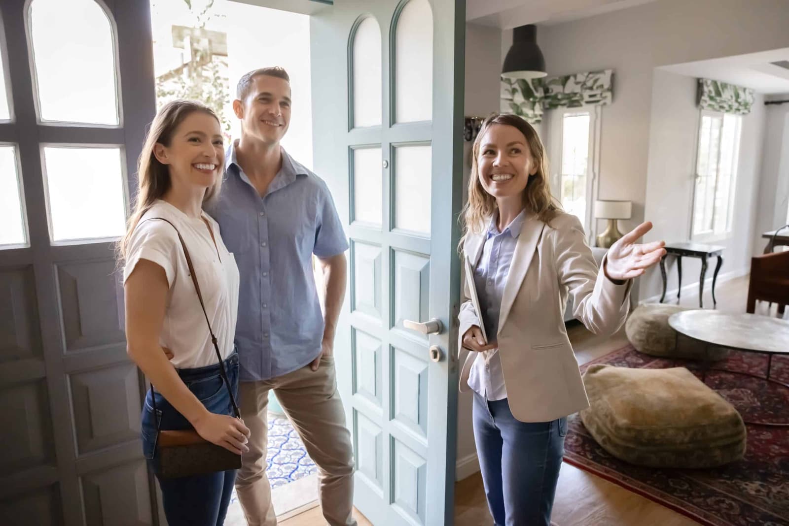 Letting agent welcoming a couple into a bright living room